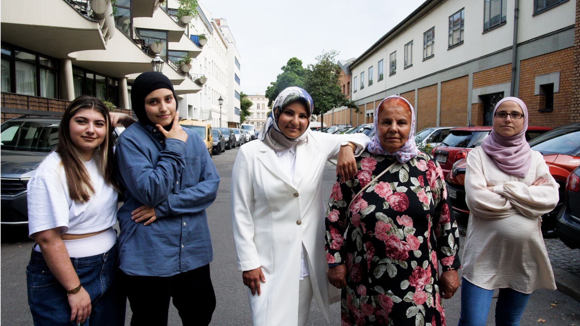 Fünf Muslimas stehen nebeneinander auf einer Straße.