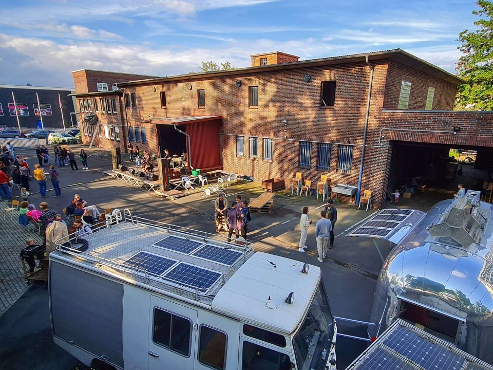 „Hands On // Kassel 2026“ findet in der Nachrichtenmeisterei, Schillerstraße 73, 34117 Kassel, statt. Kassel ist aufgrund seiner zentralen Lage ideal: Aus allen Regionen Deutschlands ist die Stadt schnell und unkompliziert erreichbar. Die kurzen Anreisewege erleichtern nicht nur die Teilnahme, sondern reduzieren auch die ökologische Belastung durch Reisen. Die Nachrichtenmeisterei ist ein besonderer kreativwirtschaftlicher Veranstaltungsort und zugleich kreatives Labor für Geschichten, Medien und Begegnung. In unmittelbarer Nachbarschaft zu Universität, Kunsthochschule und Zentrum für Kreativwirtschaft entstehen hier neue Ideen und ungewöhnliche Perspektiven. Für zwei Tage wird das Haus zum offenen „Newsroom“ des Netzwerks – mit Räumen für Arbeitssessions in kleinen Gruppen, Workshop-Formate mit etwa 15 Personen und Plenumsformate mit rund 100 Menschen. Betreiber der Nachrichtenmeisterei ist Sebastian Fleiter, Kultur- und Kreativpilot der ersten Stunde. Er fungiert als offizieller Veranstalter des Festivals und öffnet mit seinem Haus die Türen dafür, dass das Netzwerk der Kultur- und Kreativpilot*innen seine Energie mitten in Kassel entfalten kann.